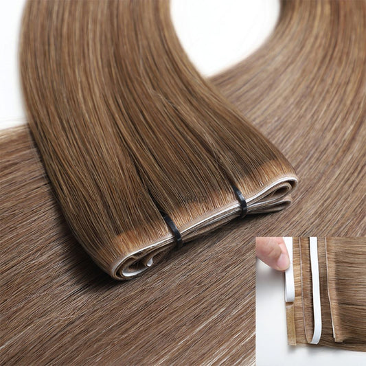 A stylist using professional shears to cut a continuous long strip tape hair extension to size without fraying.