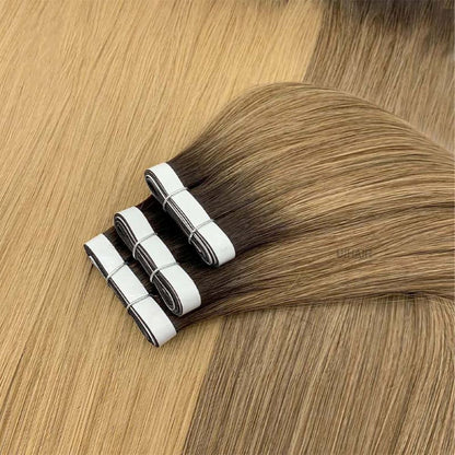 Model wearing a high messy bun showing completely invisible dark rooted tape weft tracks underneath.